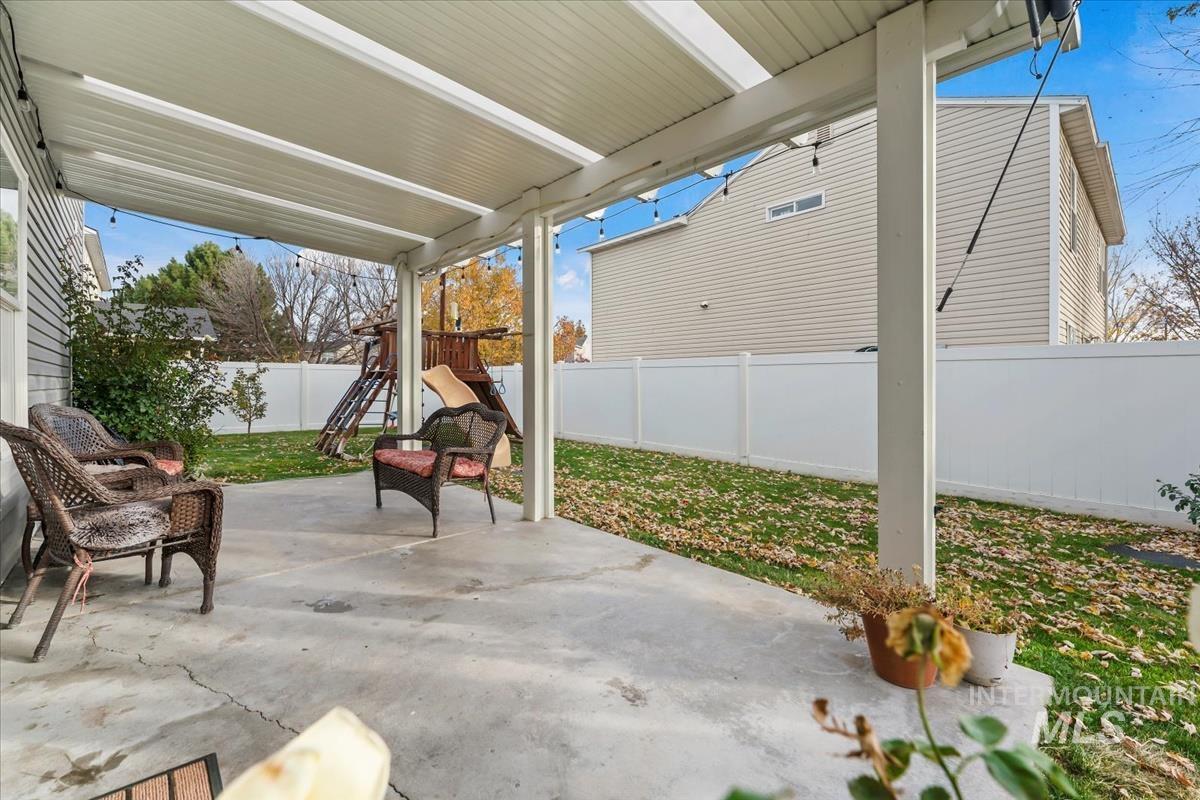 Fenced backyard with a patio area and a playground