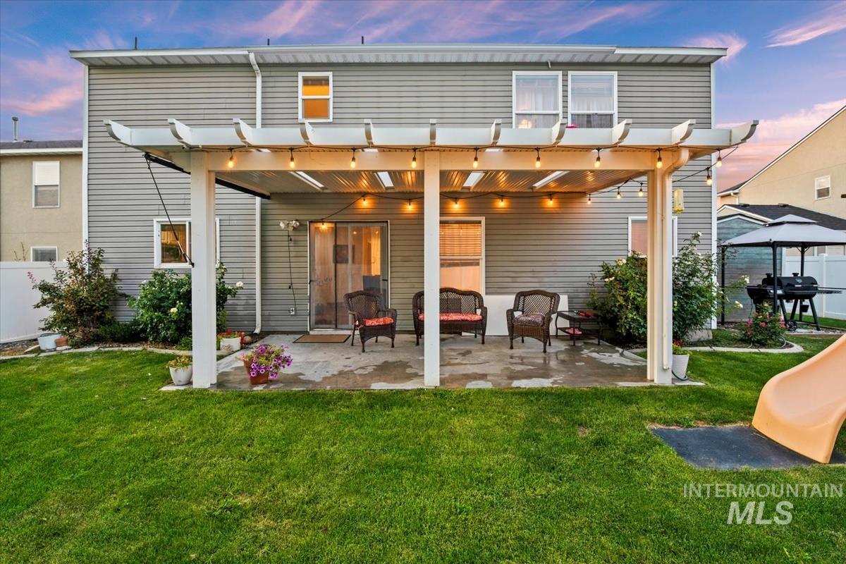 Rear view of property with a patio area and a lawn