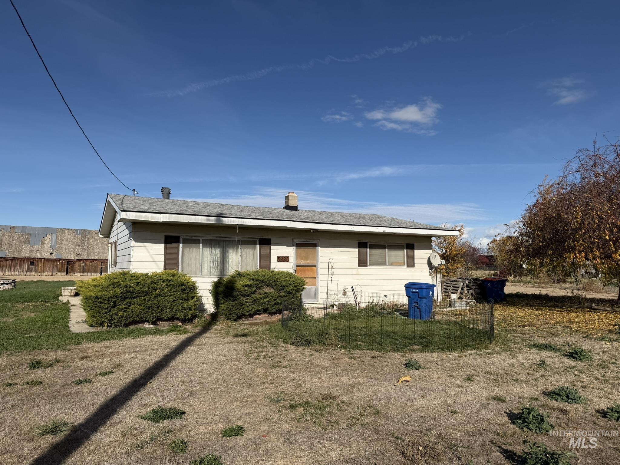 View of front of property with a chimney, a front lawn, and roof with shingles
