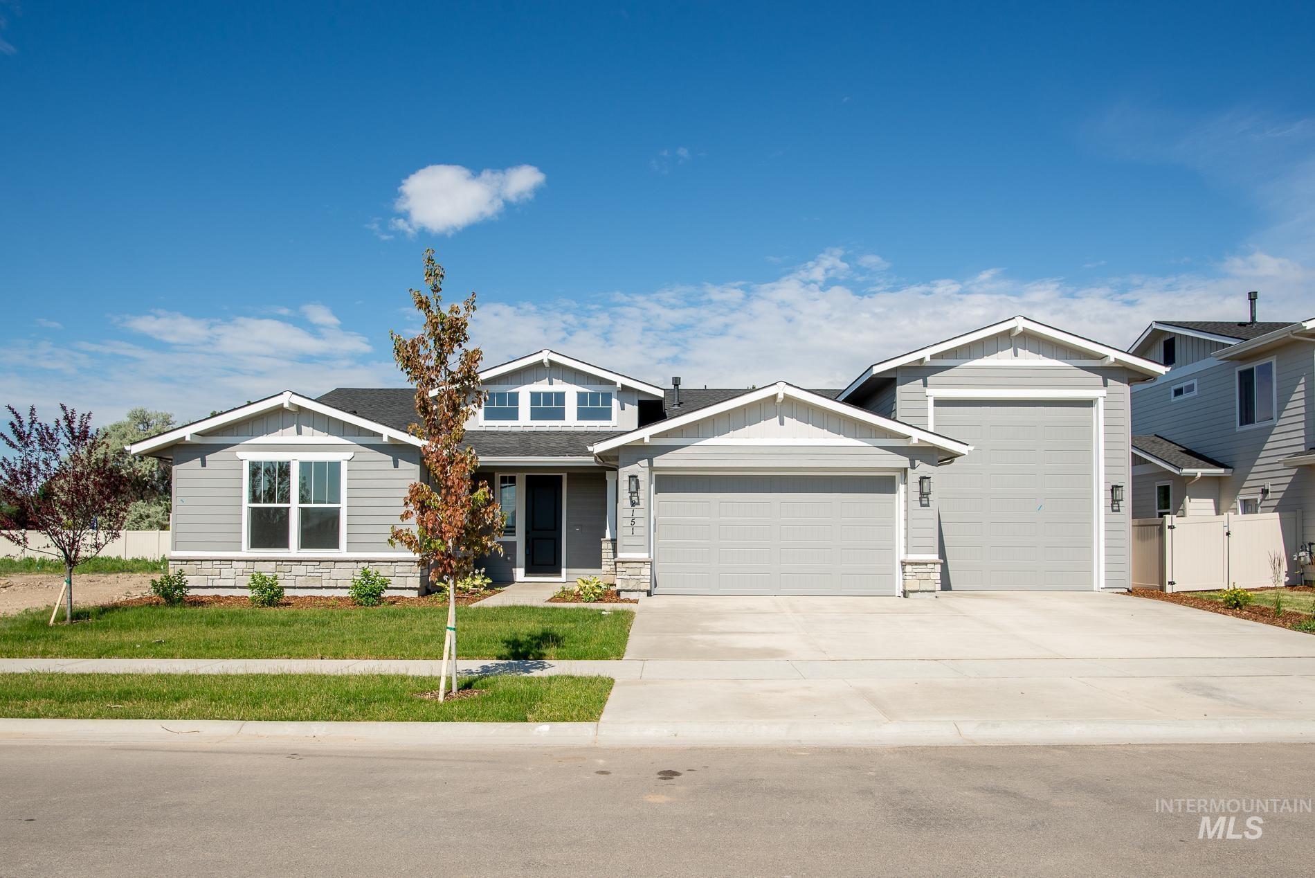 Craftsman-style home featuring stone siding, board and batten siding, concrete driveway, and an attached garage