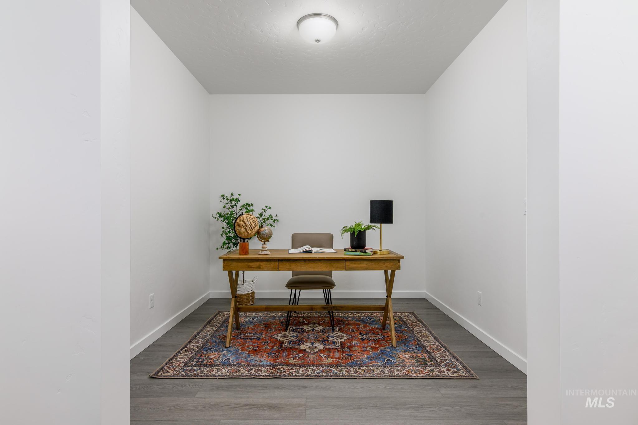 Office space with wood finished floors and a textured ceiling
