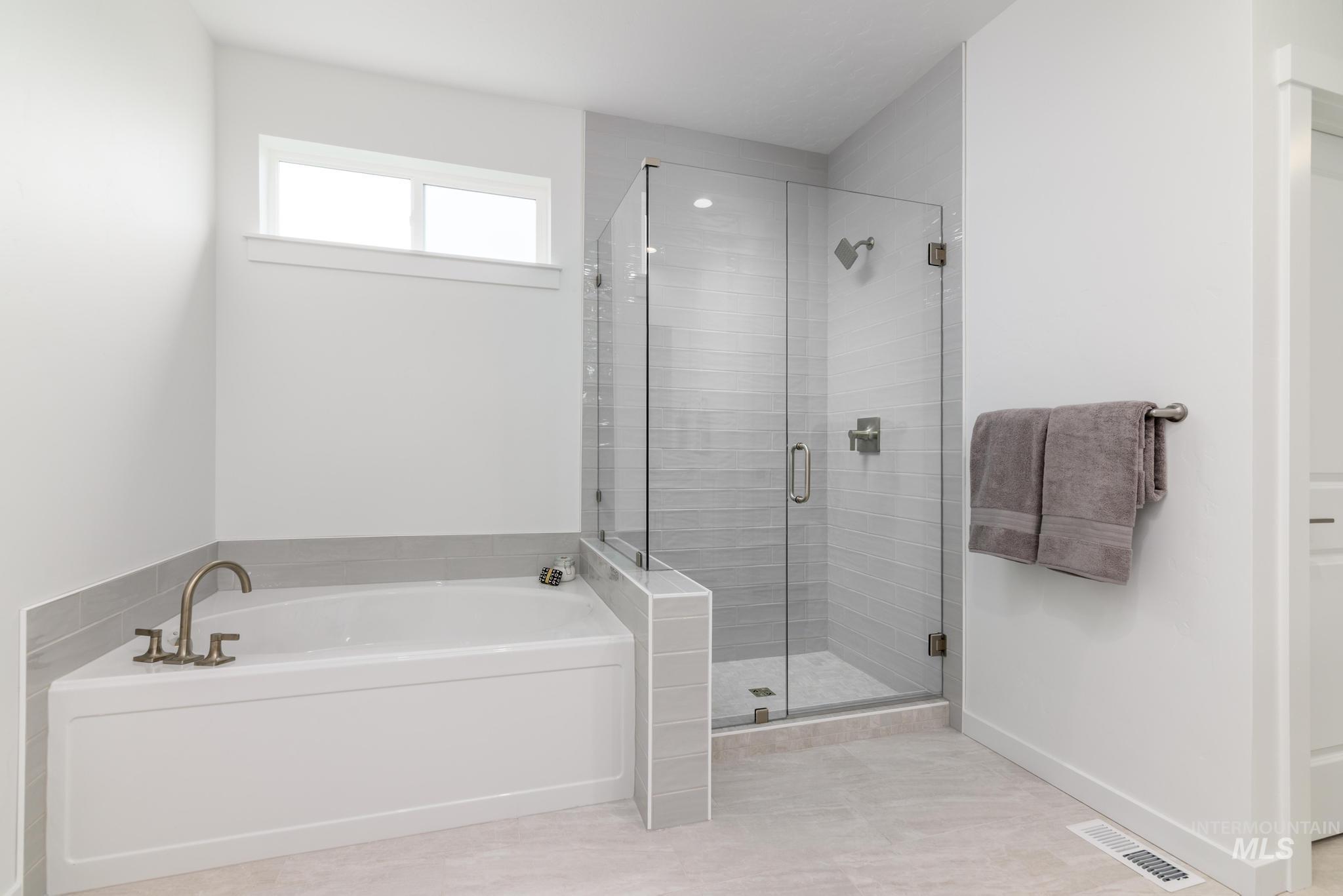 Bathroom featuring a garden tub and a shower stall