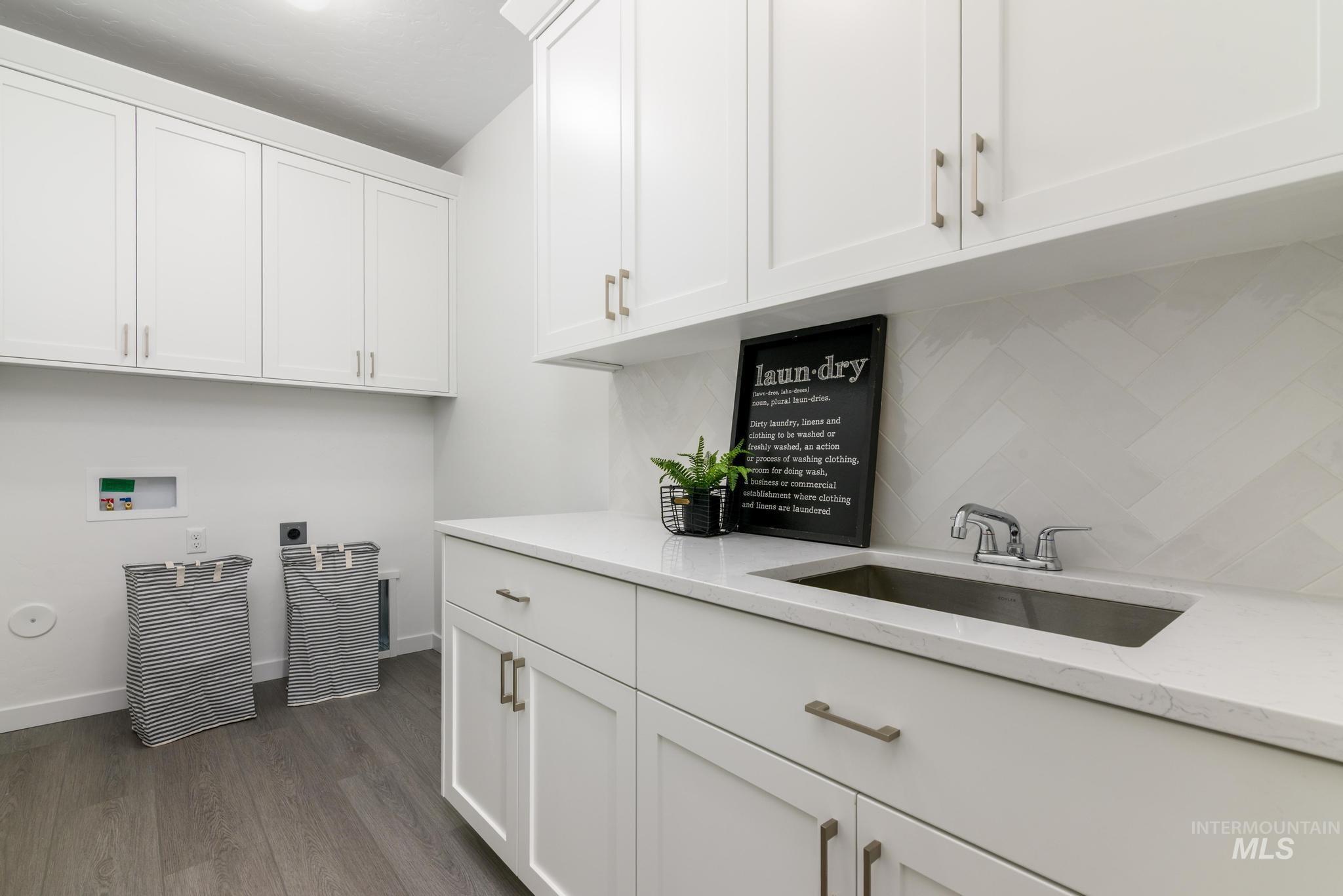 Laundry area featuring washer hookup, dark wood finished floors, cabinet space, and electric dryer hookup
