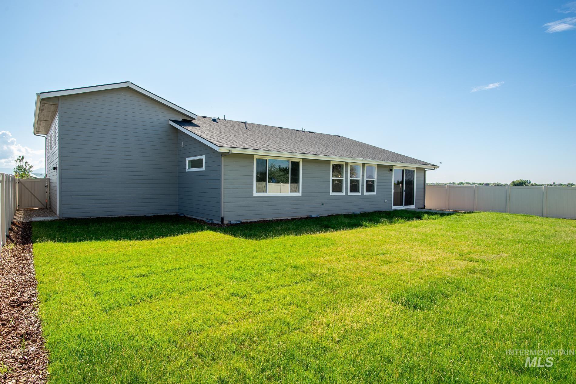 Rear view of property with a fenced backyard and roof with shingles