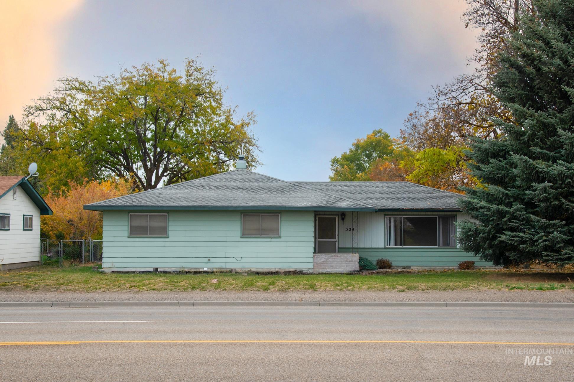 Ranch-style house with roof with shingles and a chimney