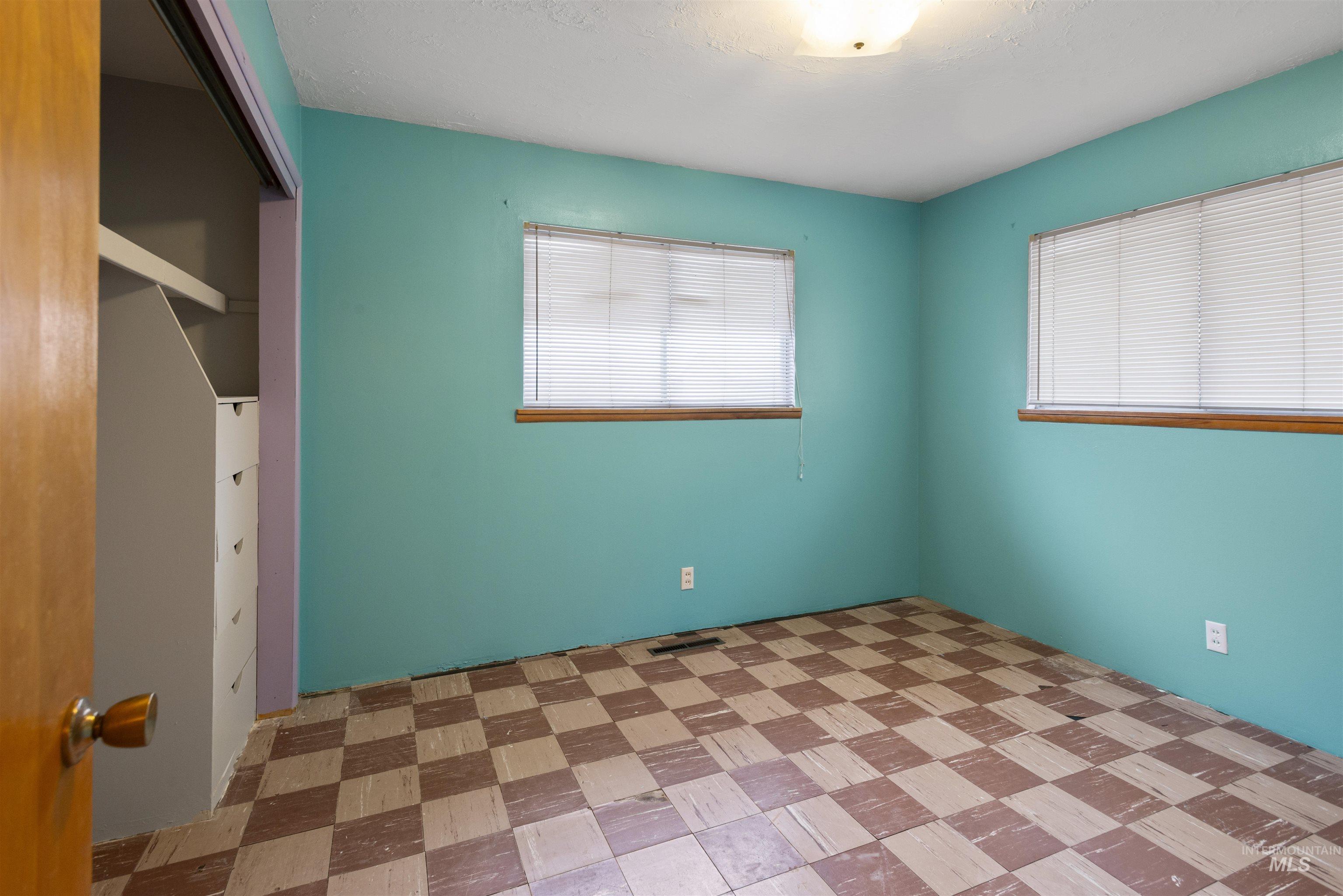 Unfurnished room with healthy amount of natural light and a textured ceiling