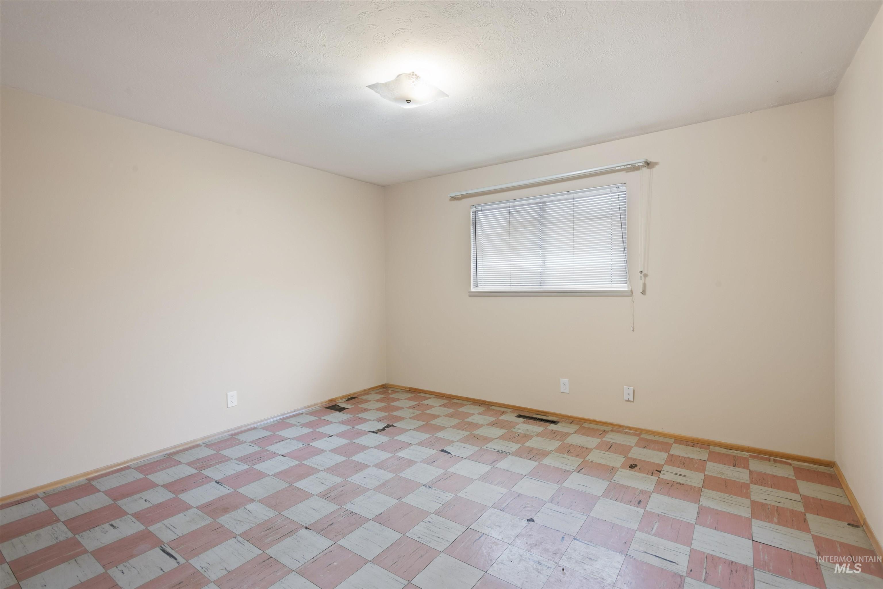 Unfurnished room featuring baseboards and a textured ceiling