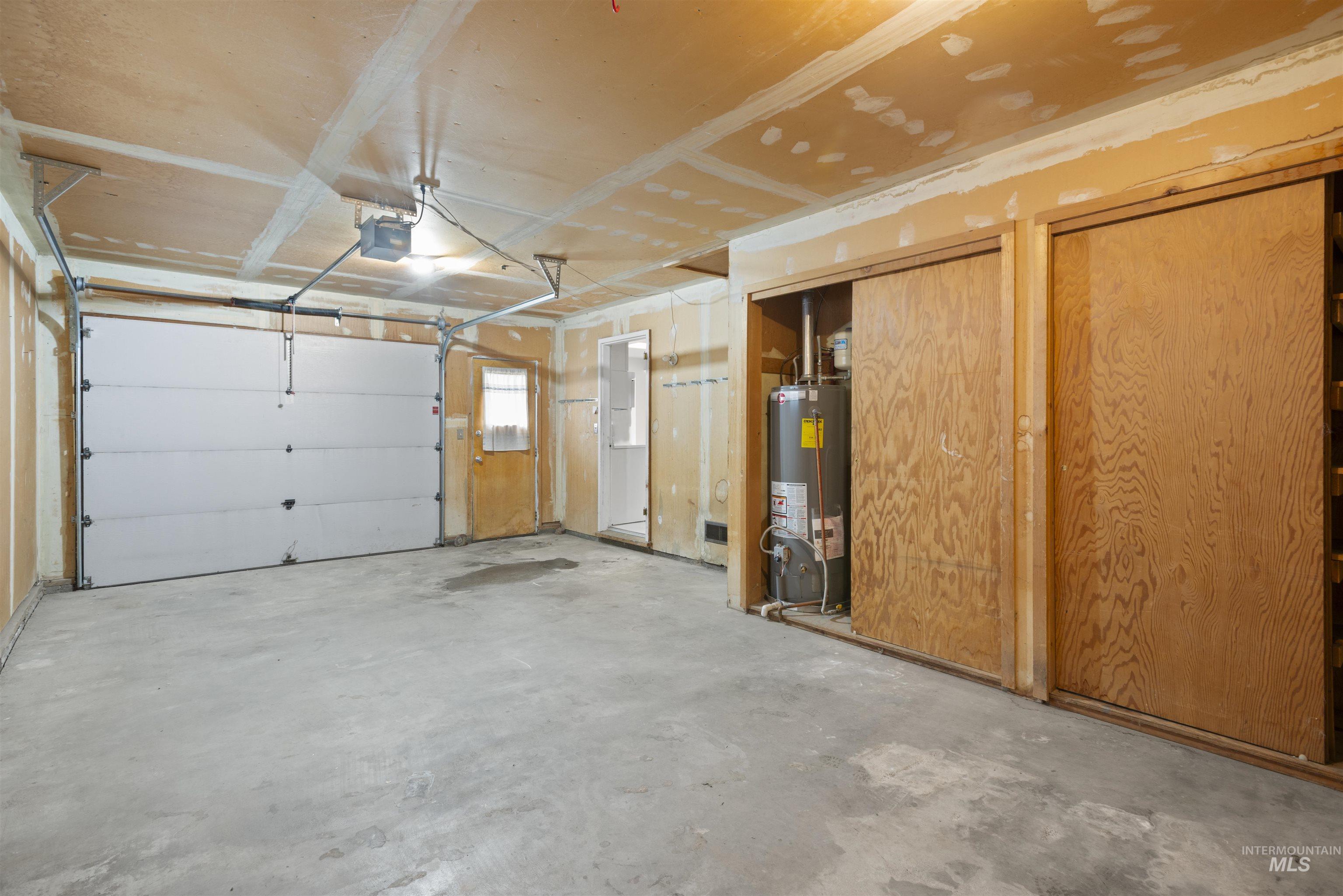 Garage featuring gas water heater and a garage door opener