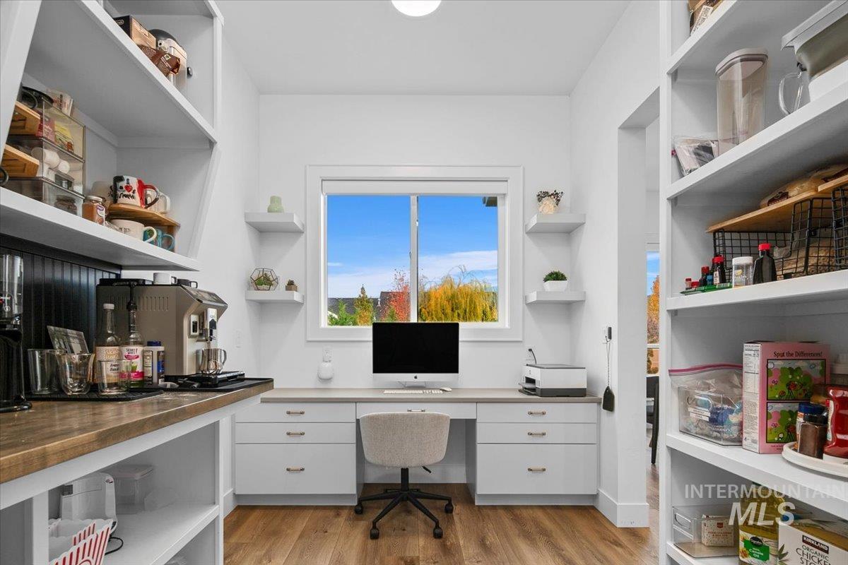 Home office featuring built in desk and light wood finished floors