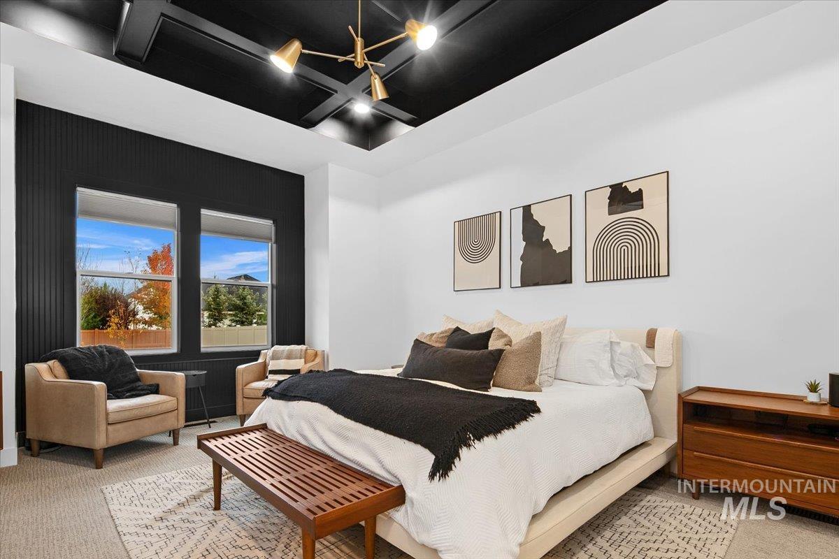 Carpeted bedroom featuring coffered ceiling and beamed ceiling