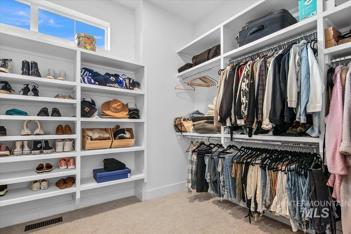 Walk in closet with light colored carpet