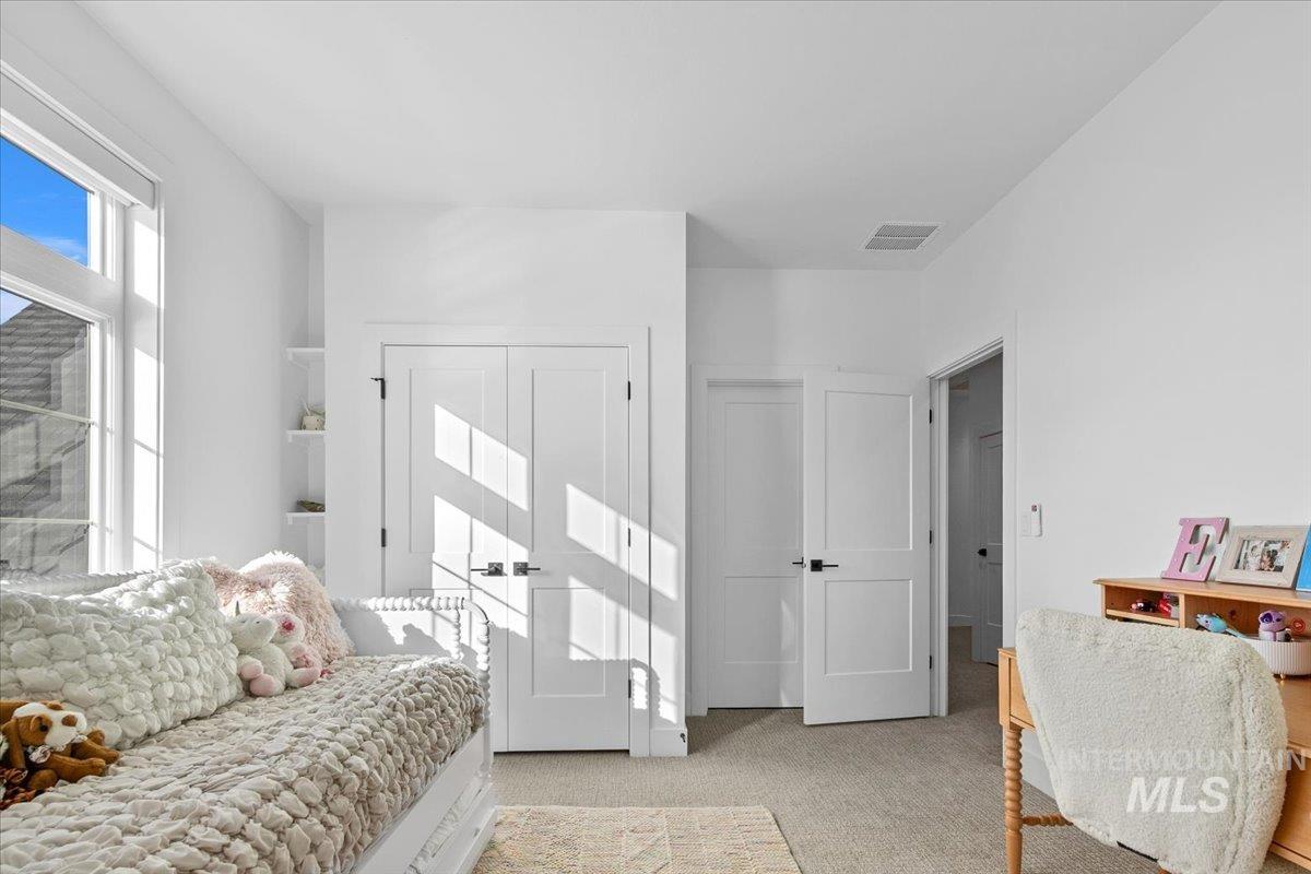 Bedroom with light colored carpet and a closet