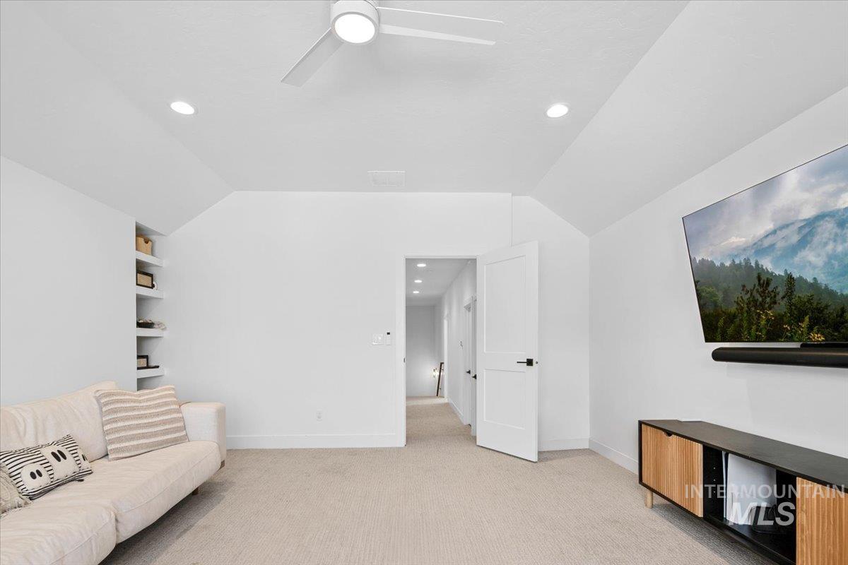 Living room with light colored carpet, recessed lighting, vaulted ceiling, and ceiling fan