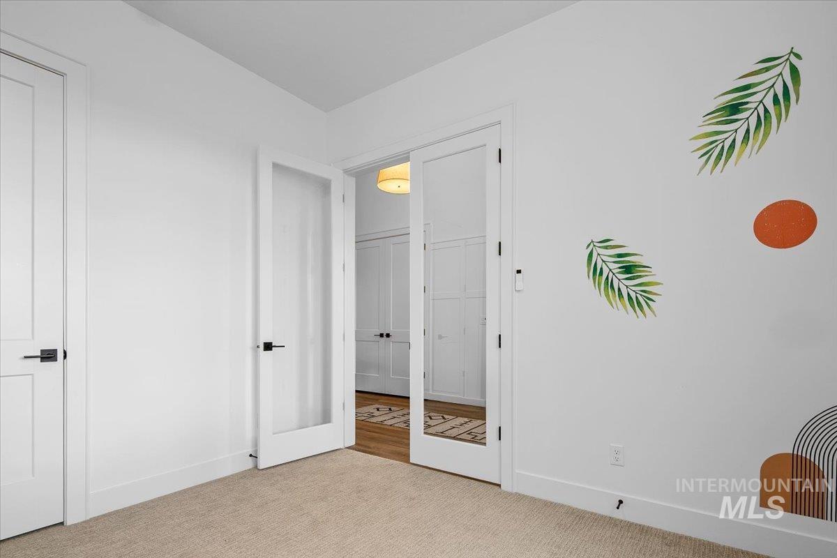 Unfurnished bedroom featuring carpet flooring and french doors