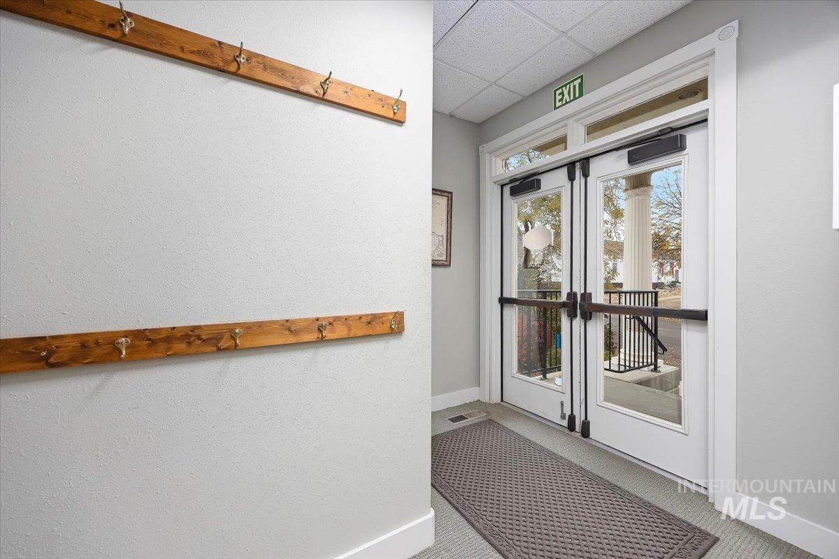 Doorway with a drop ceiling and carpet floors