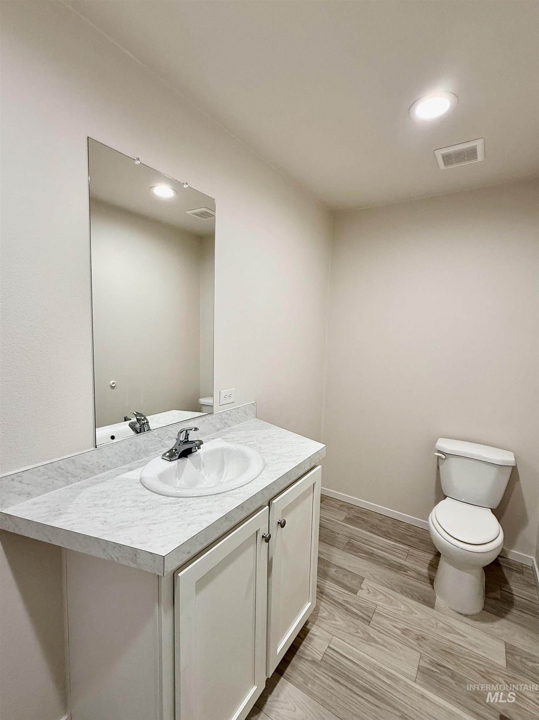 Bathroom with vanity, light wood-type flooring, and recessed lighting