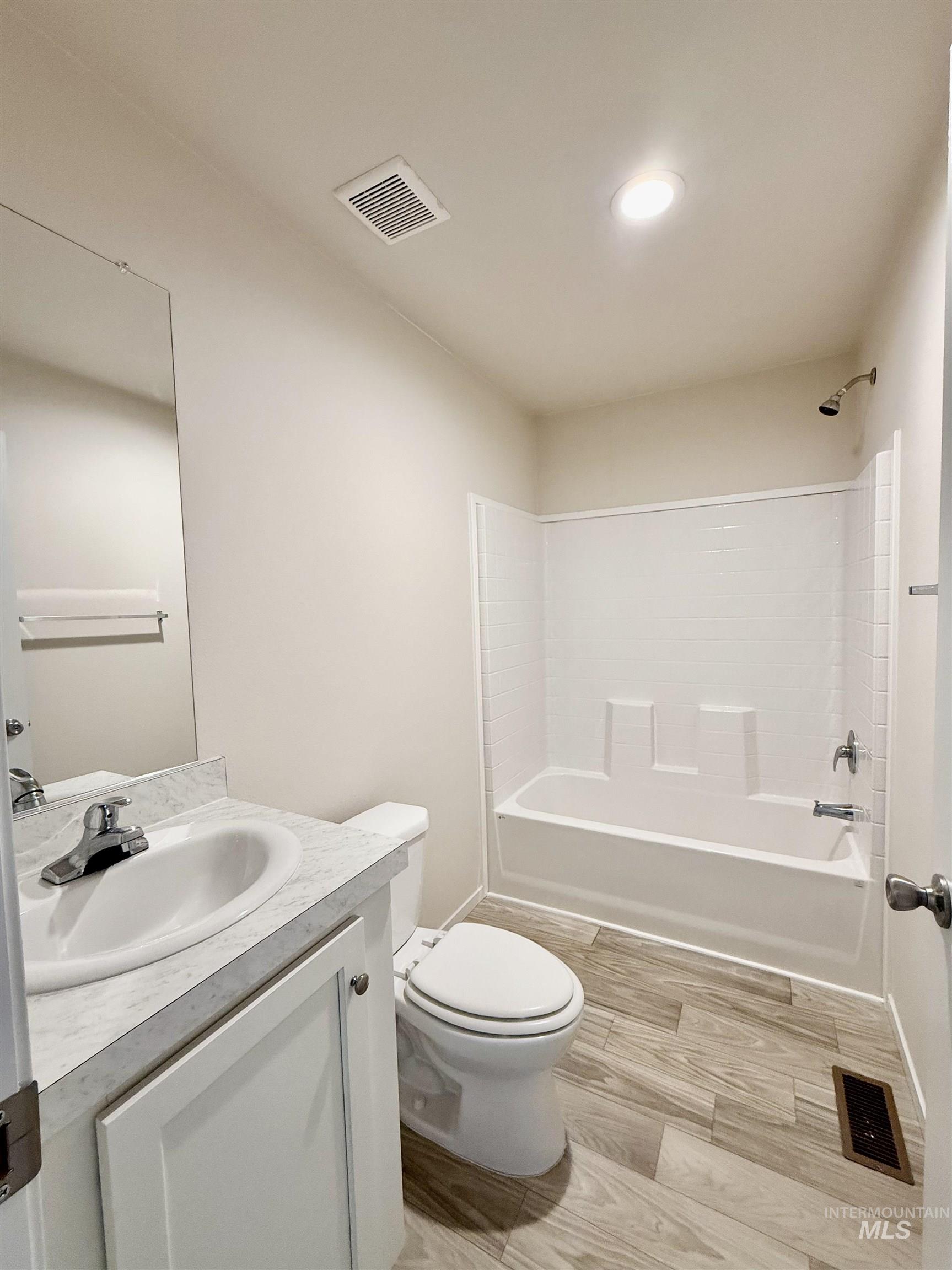 Full bath featuring vanity, light wood finished floors, and bathtub / shower combination
