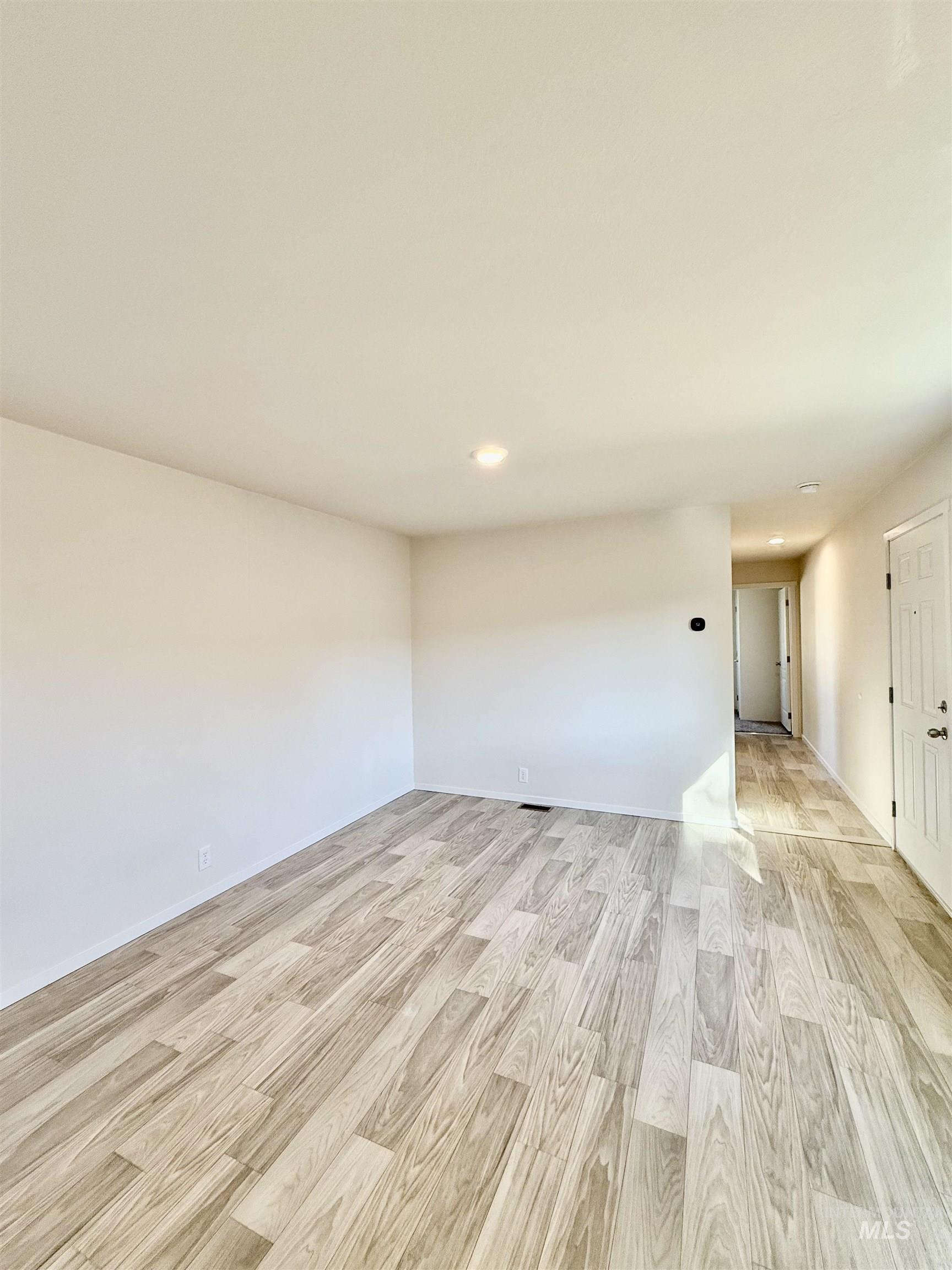 Empty room featuring light wood finished floors and recessed lighting