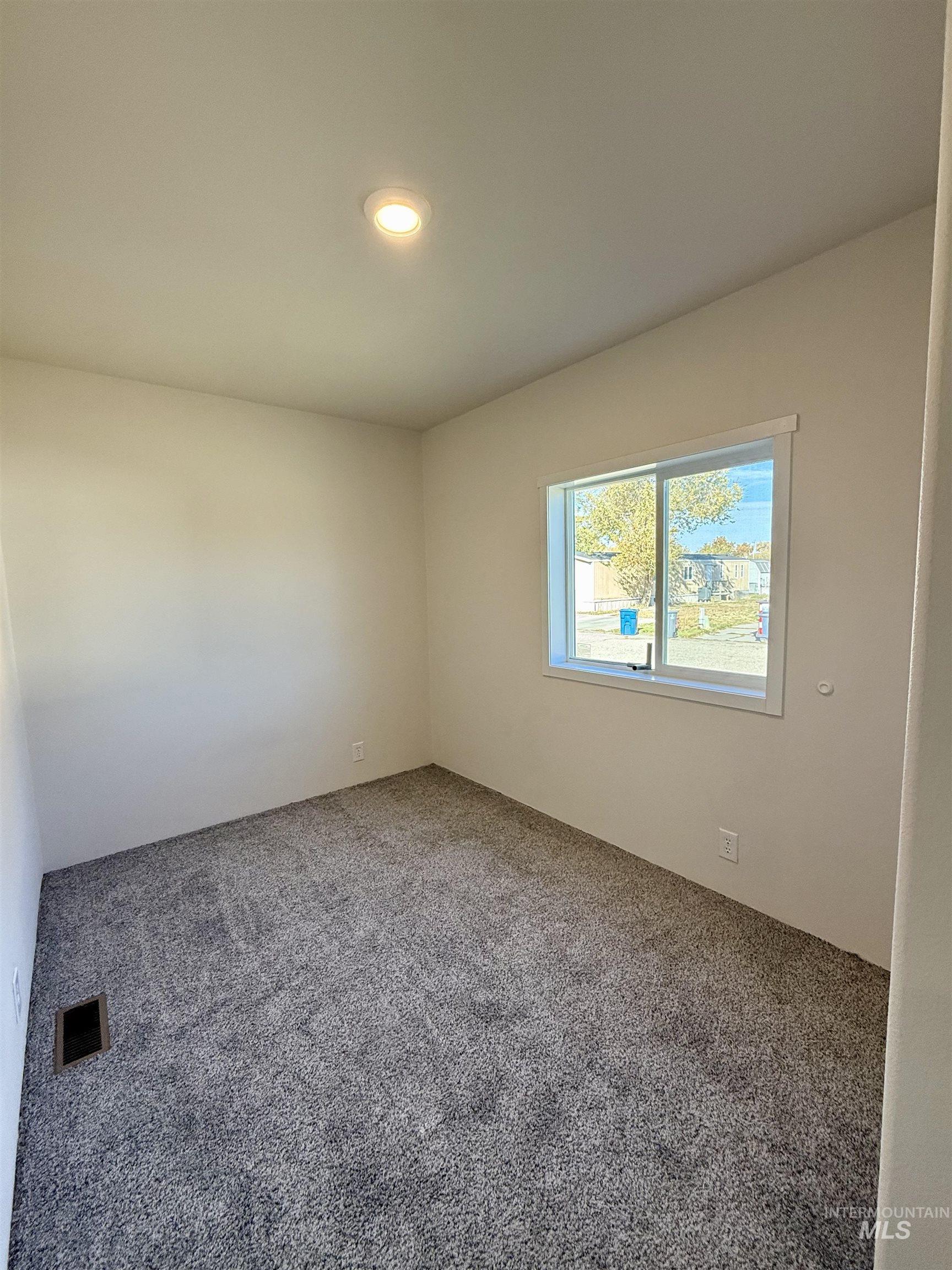 Carpeted empty room with recessed lighting
