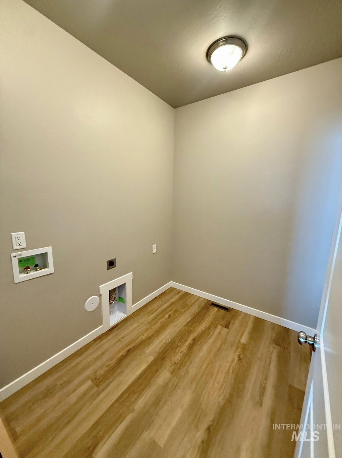 Laundry area featuring washer hookup, light wood-style floors, and electric dryer hookup