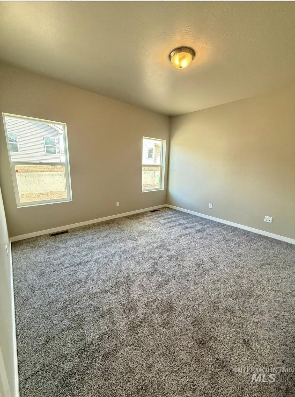 Spare room featuring carpet floors and baseboards