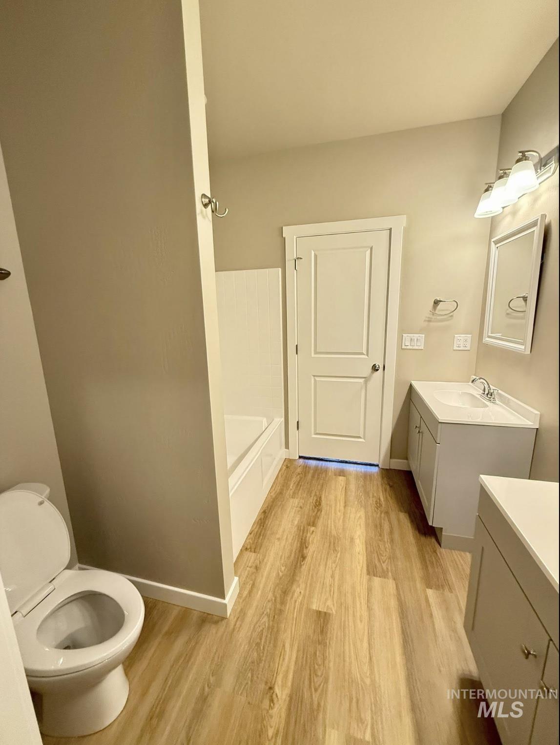 Full bath with vanity, light wood-style flooring, a bathtub, and a shower