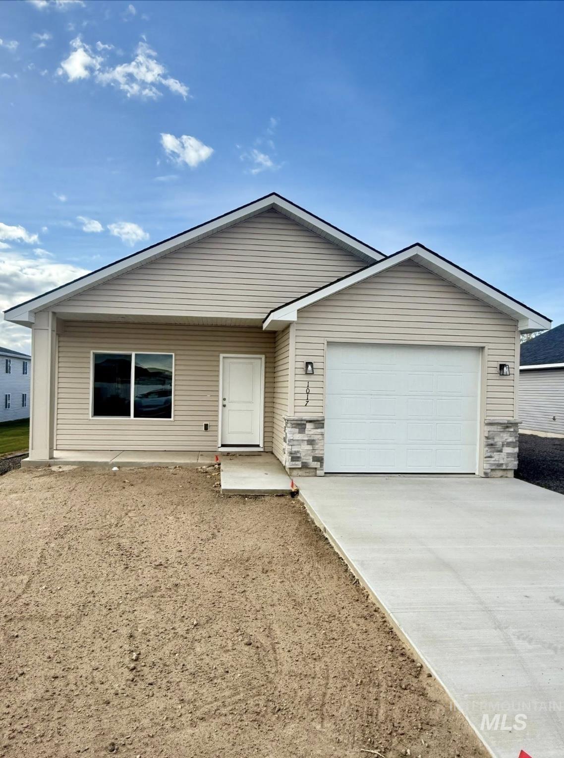 Single story home featuring concrete driveway, a garage, and stone siding