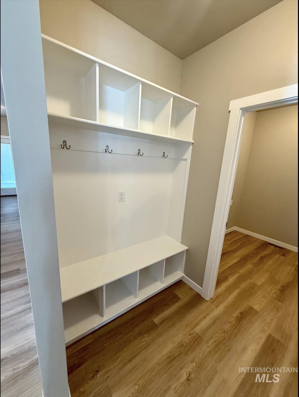 Mudroom featuring light wood-style flooring and baseboards