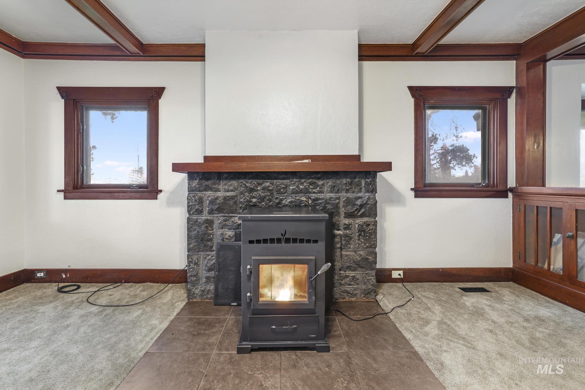 Detailed view of beam ceiling, carpet floors, and a wood stove