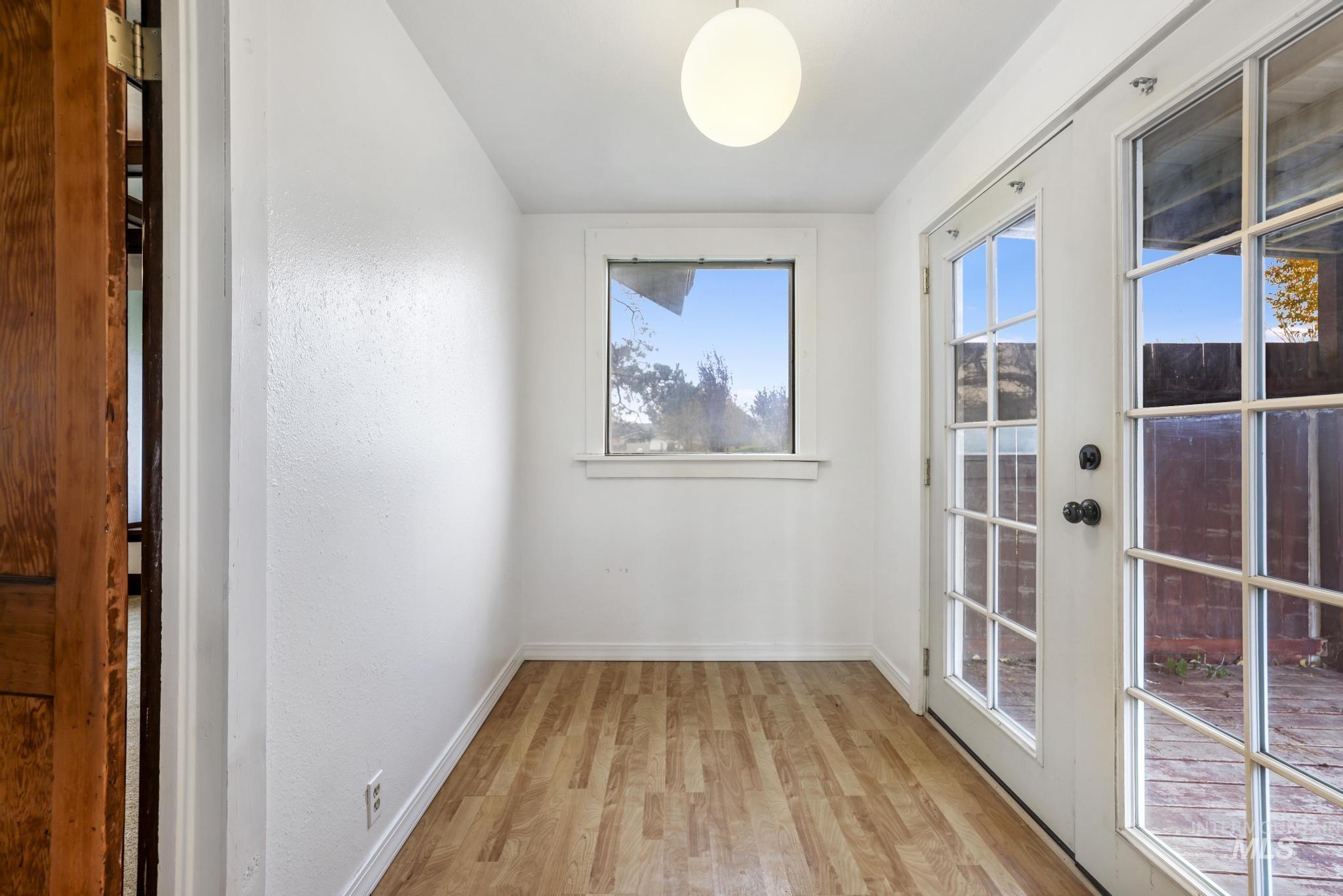 Doorway featuring wood finished floors and baseboards