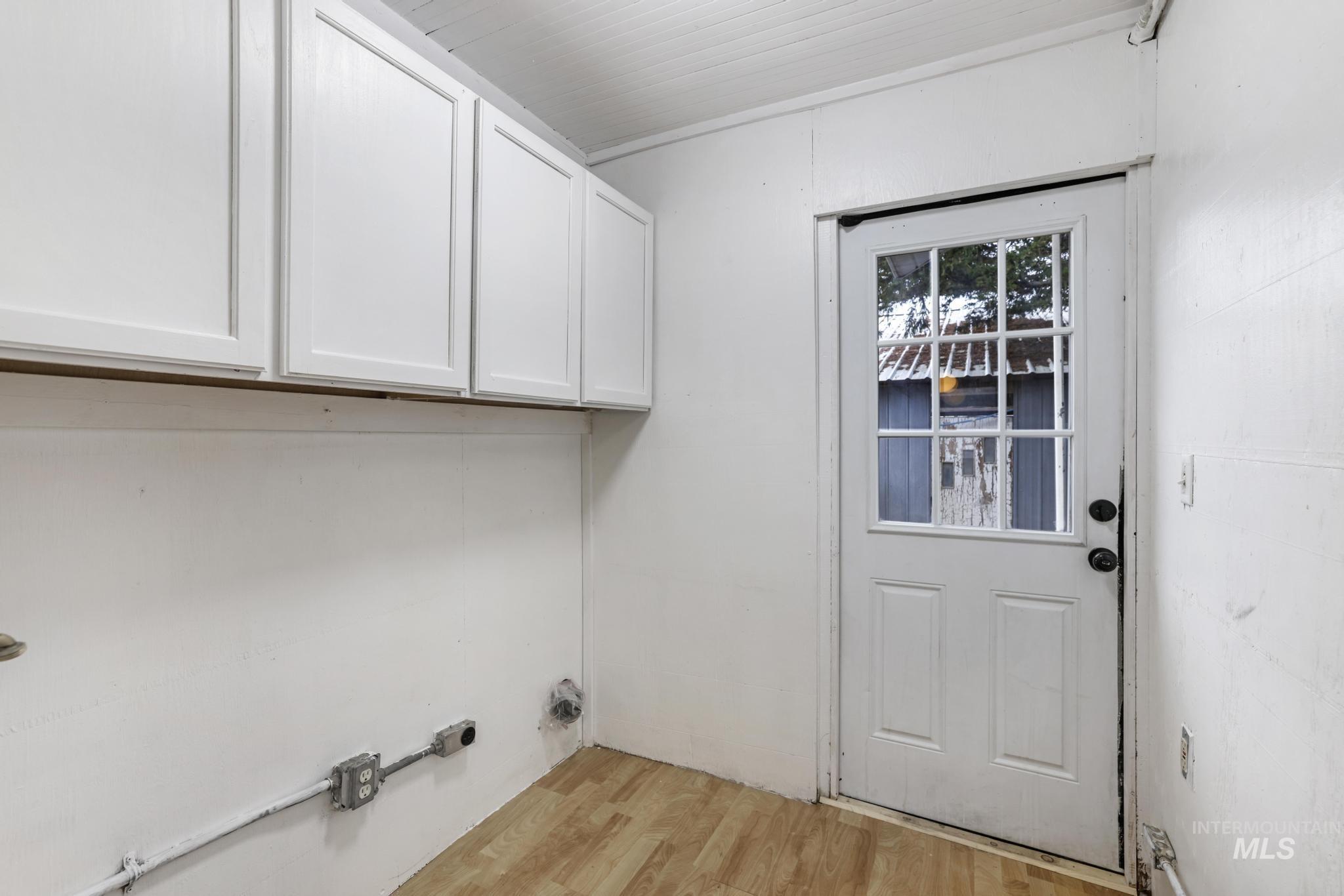 Washroom featuring light wood-type flooring and cabinet space
