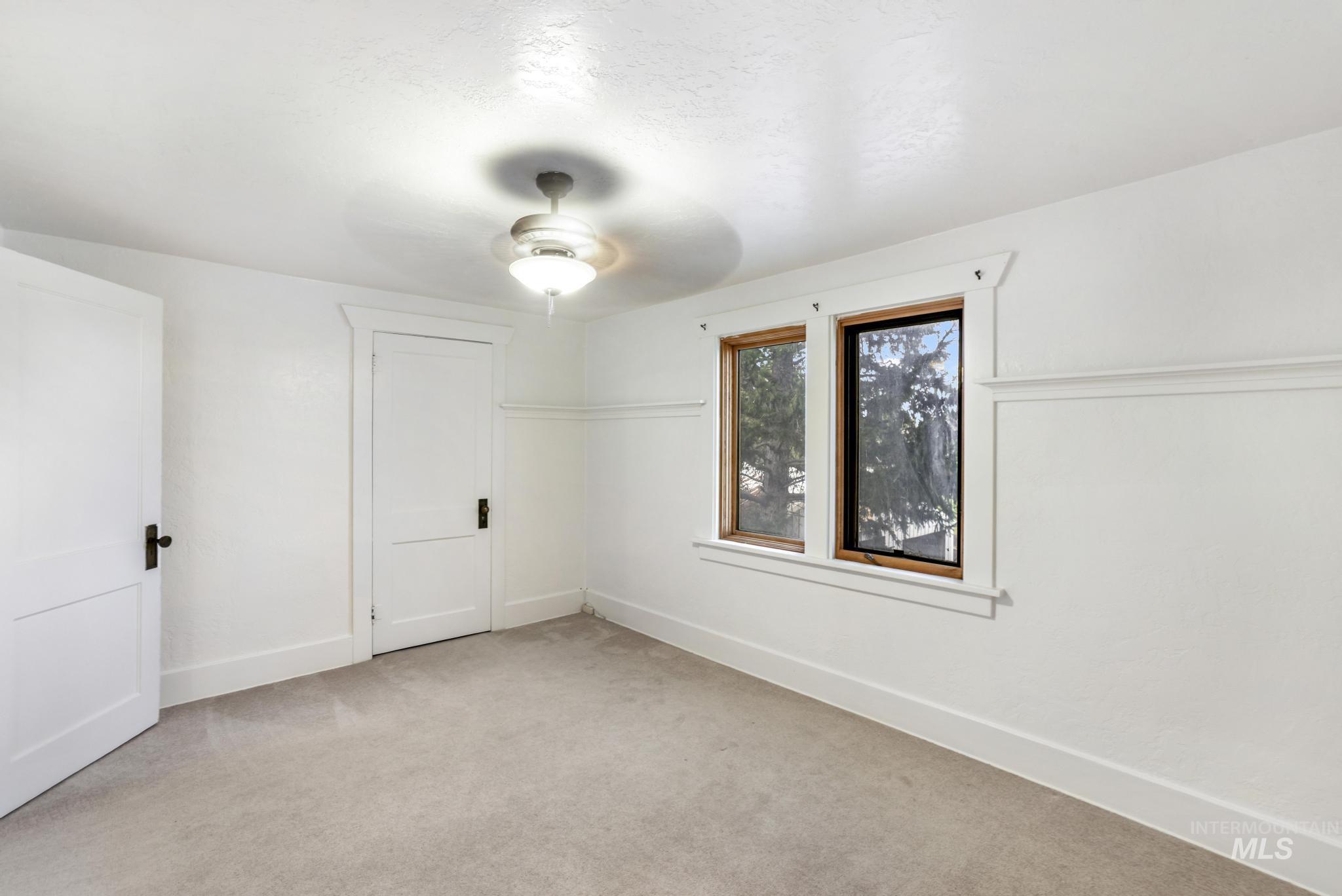 Unfurnished room featuring light carpet and ceiling fan