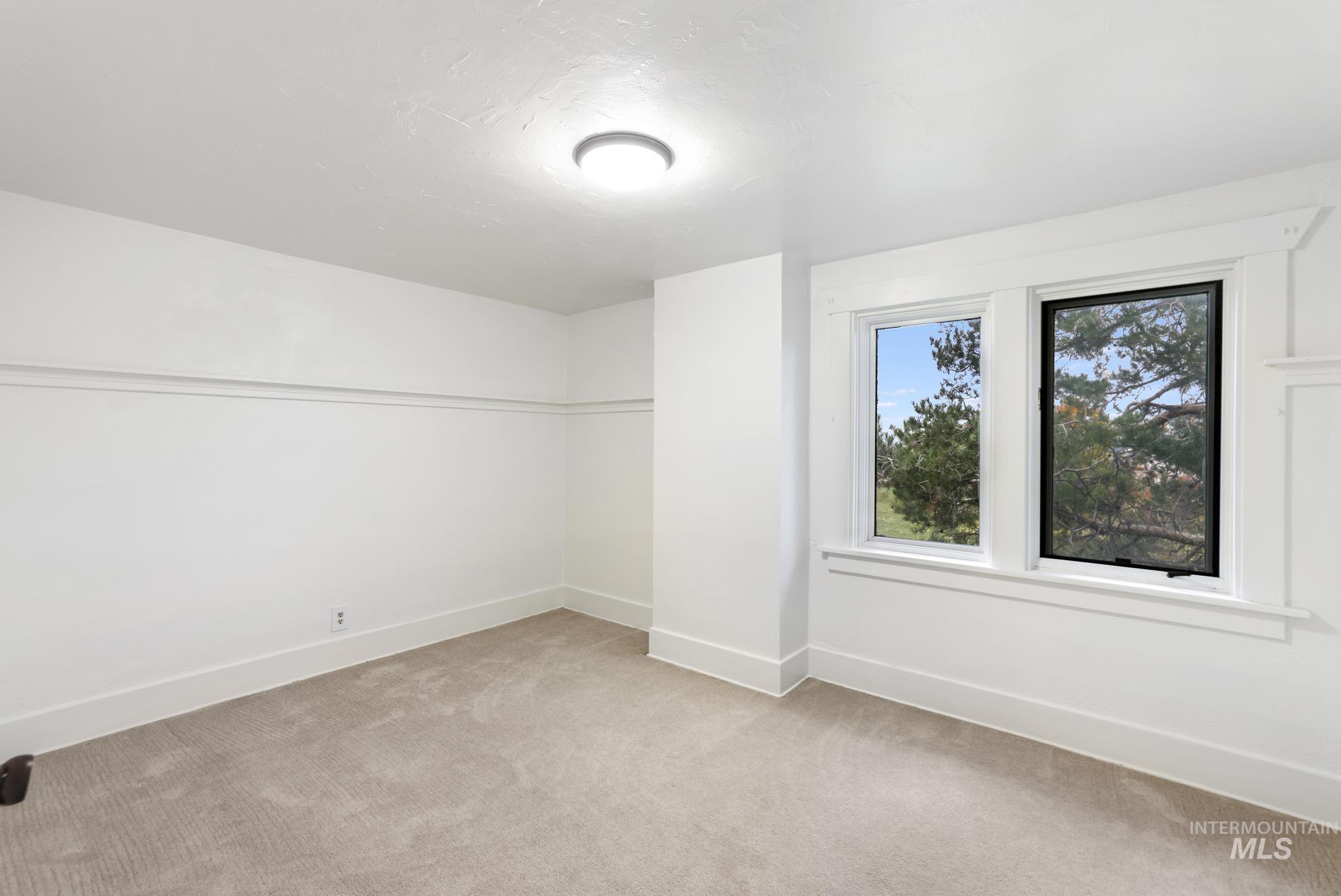 Spare room featuring baseboards and light colored carpet