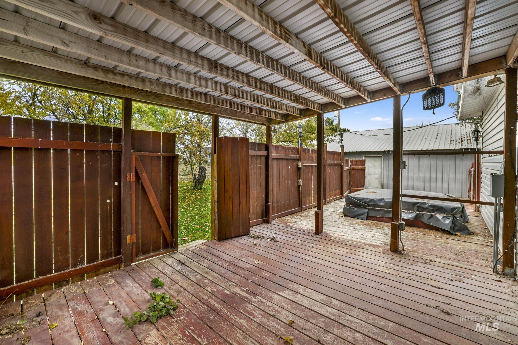 Deck featuring a fenced backyard, a jacuzzi, and a gate