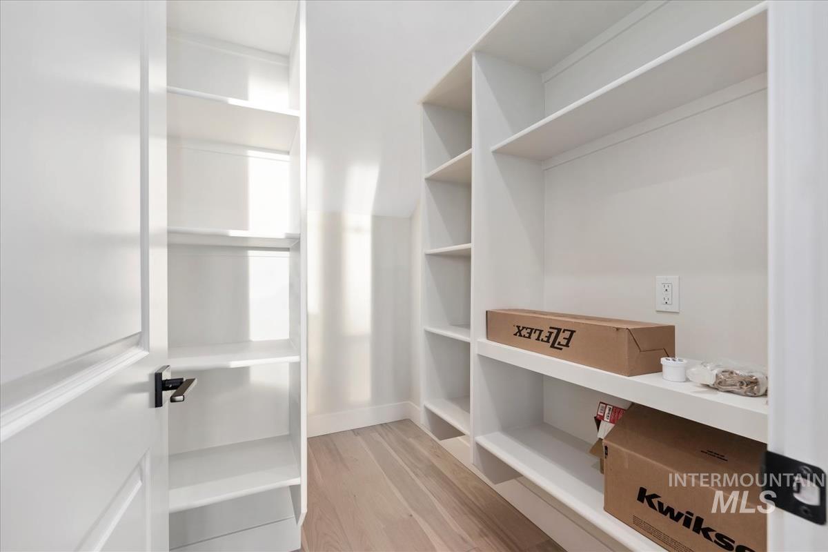 Walk in closet with light wood-type flooring