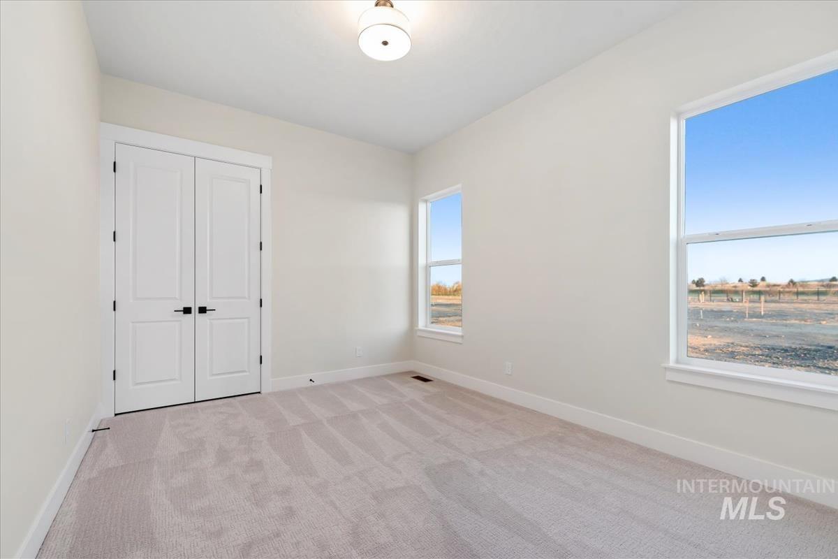 Unfurnished bedroom featuring light carpet and a closet