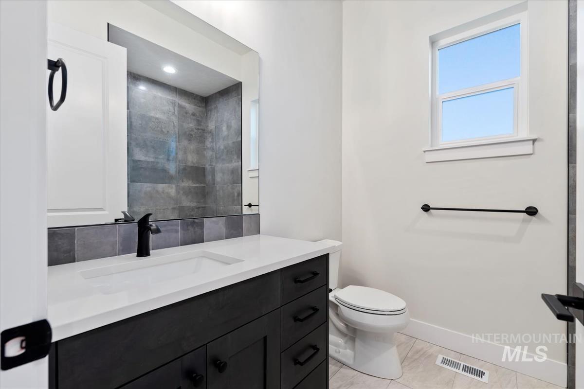 Full bathroom featuring vanity and baseboards