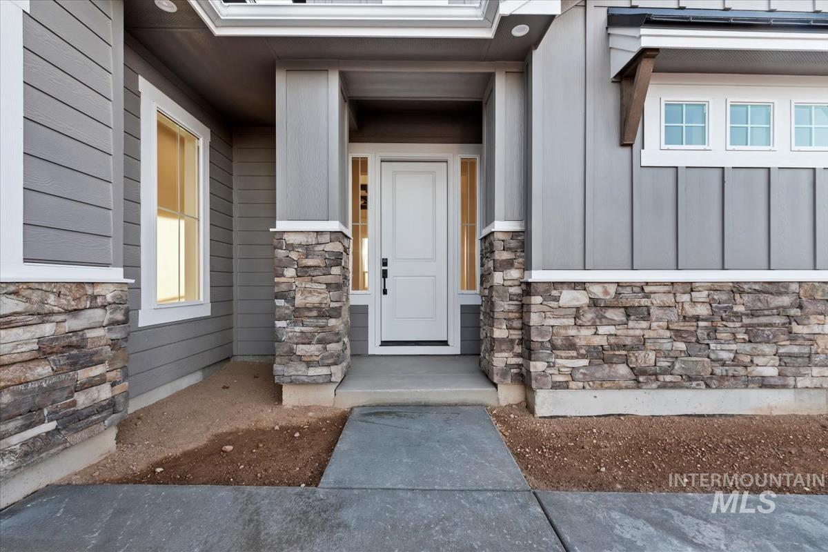 Property entrance featuring stone siding and board and batten siding