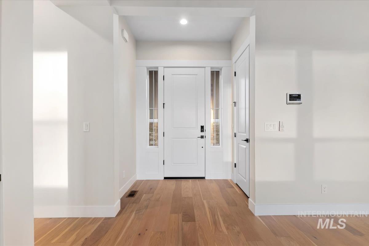 Foyer entrance with light wood-style flooring and recessed lighting
