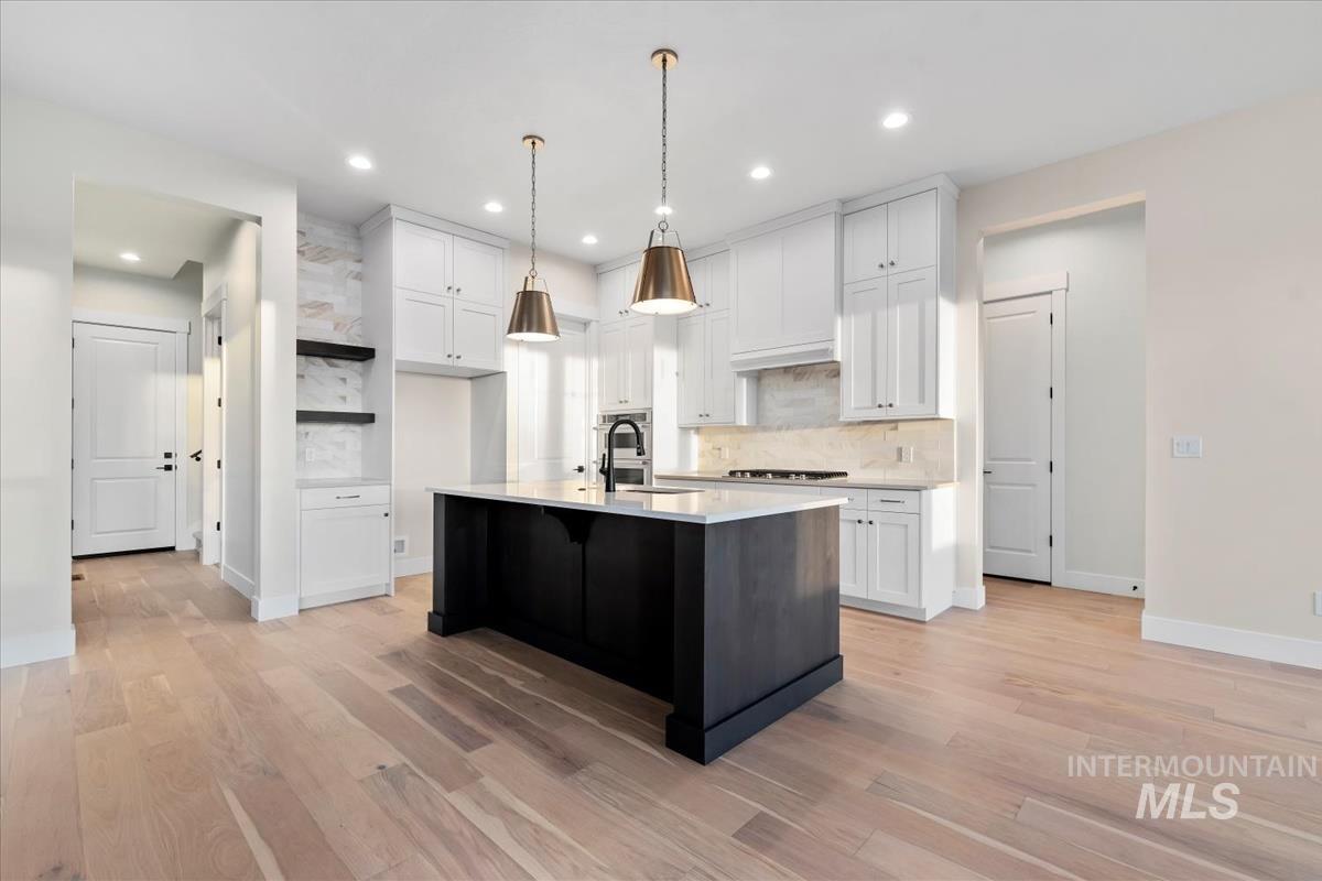 Kitchen featuring decorative backsplash, white cabinets, open shelves, light wood-style flooring, and recessed lighting