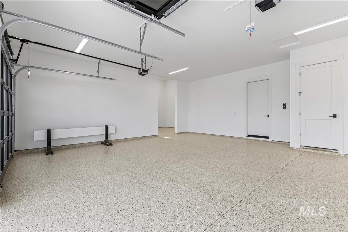 Garage with a garage door opener and baseboards