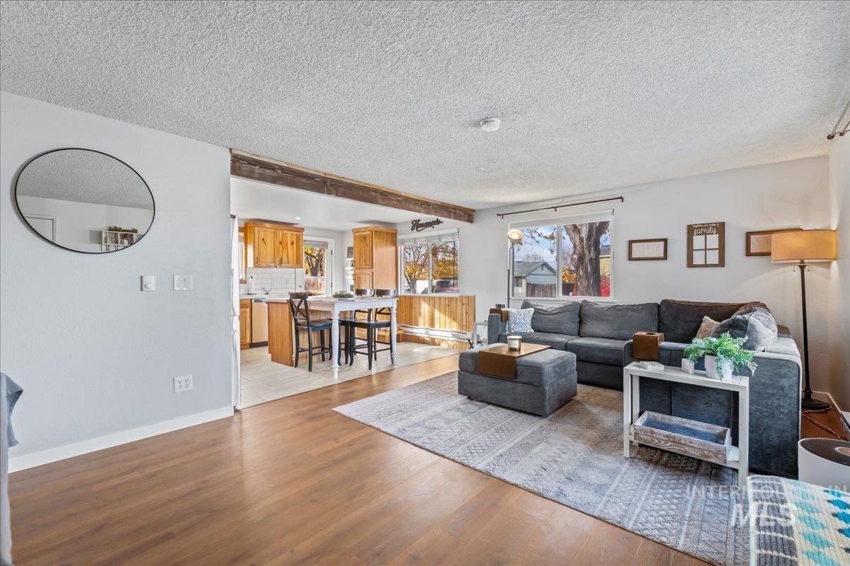 Living room featuring light wood-type flooring and a textured ceiling