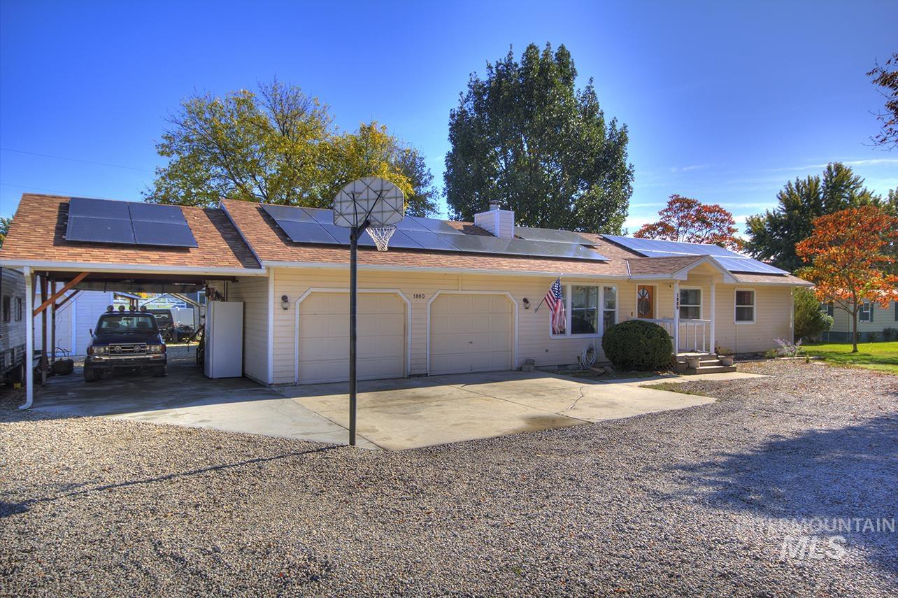Ranch-style house with driveway, an attached garage, an attached carport, and a chimney