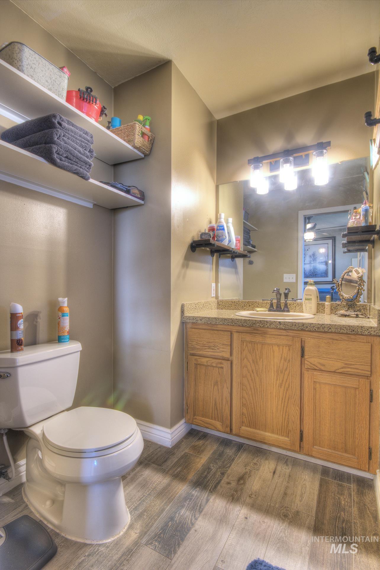 Half bathroom with vanity and dark wood-type flooring