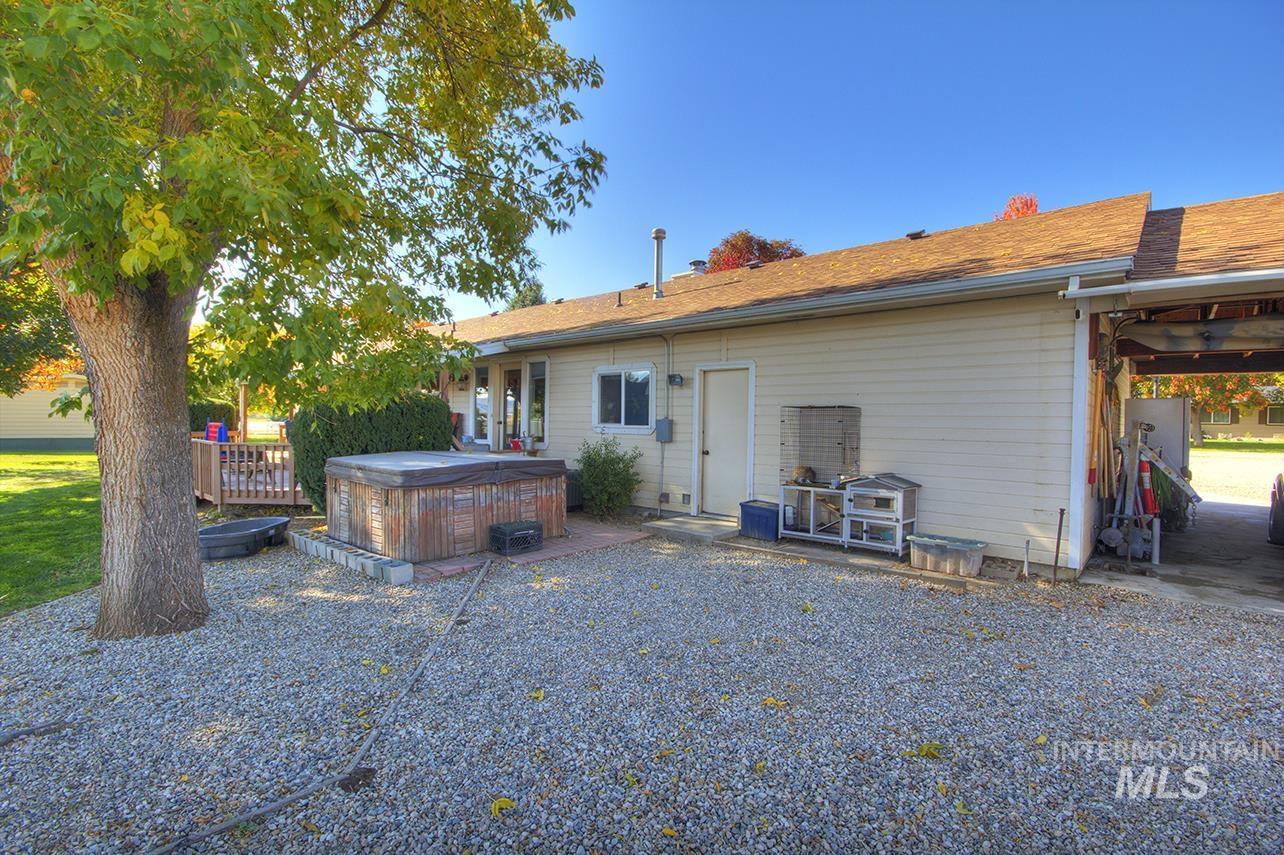 Back of property featuring a hot tub, a patio area, and a wooden deck