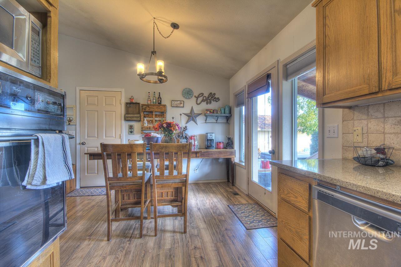 Dining room with vaulted ceiling, dark wood-type flooring, and a chandelier