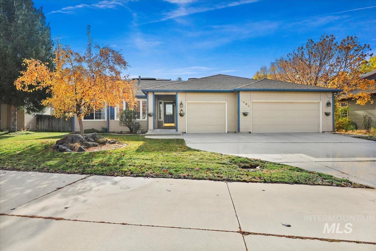 Ranch-style home with concrete driveway, a front lawn, and an attached garage