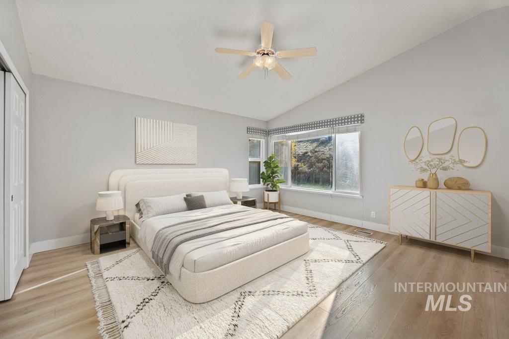 Bedroom featuring vaulted ceiling, light wood-style floors, a ceiling fan, and a closet
