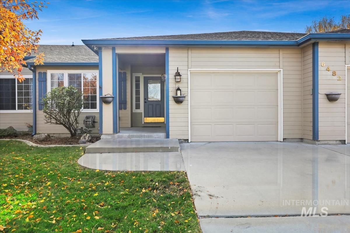 Ranch-style home featuring concrete driveway, a front lawn, and a garage