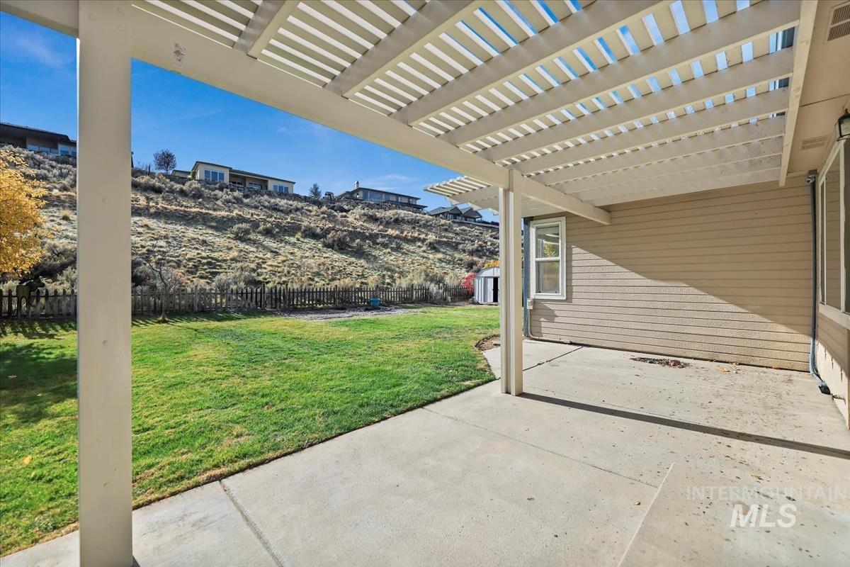 Fenced backyard featuring a pergola and a patio